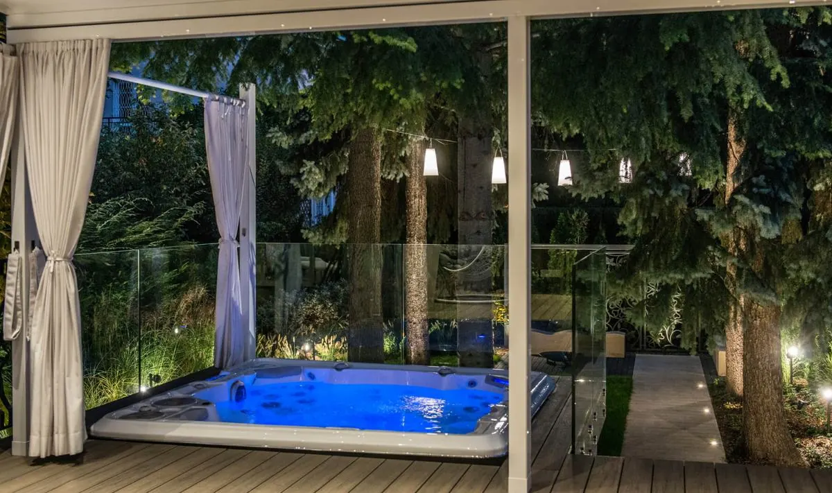 Jacuzzi Hydropool na tle panoramy leśnego ogrodu, wieczorem
